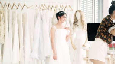 Genç düğün elbise Tasarımcısı çalışma. Genç Asyalı kadın müşterisi yeni düğün elbise denemek izin. Küçük işletme kavramı.