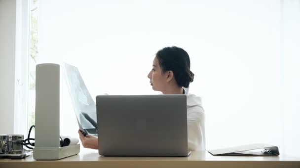 Jeune Femme Asiatique Médecin Assis Sur Son Bureau Examiner Profil — Video