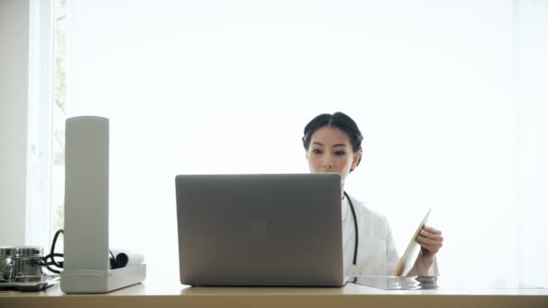 Jonge Aziatische Vrouw Arts Zittend Haar Bureau Onderzoeken Patiënt Medisch — Stockvideo