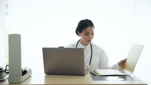 Jovem Mulher Asiática Médico Sentado Sua Mesa Examinar Perfil Médico — Vídeo de Stock