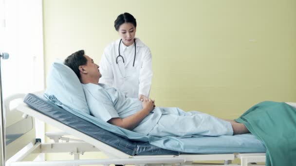 有病人的医生年轻的女医生在床上与医院的一名老年患者交谈 老年医疗和保险概念 — 图库视频影像