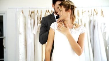 Romantik düğün çift pahalı kıyafet Dükkanı. Dostum gelin elbise, kadın ve erkek kolye kadınını sürpriz veren beyaz. Romantik genç çift kavramı.