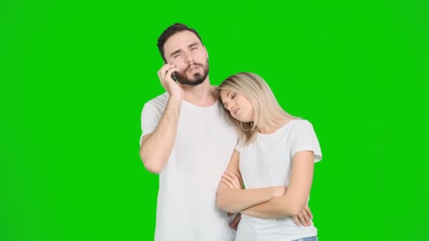 若いカップルの携帯電話を使用して方向を見つけようとして 電話で話して 緑の画面 白い男性と女性 クロマキー — ストック動画