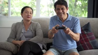 Konsol oyun oynarken televizyonu kapat o açtıktan sonra üst düzey Asya adam karısıyla üzgün. Üst düzey yaşam tarzı kavramı.