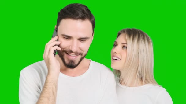 若い男が電話で話をし 緑の画面で大きな驚きで素晴らしいニュースを受けました 白人男性と女性 クロマキー — ストック動画