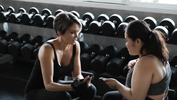 Jonge Aziatische Vrouw Zit Praten Met Haar Kaukasische Personal Trainer — Stockvideo