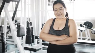 Genç şişman Asyalı kadın portresi. Arka planda jimnastik salonu var. Otantik Fitness yaşam tarzı konsepti.