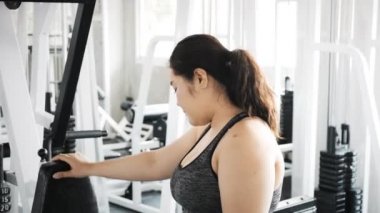 Genç şişman Asyalı kadın portresi. Arka planda jimnastik salonu var. Otantik Fitness yaşam tarzı konsepti.