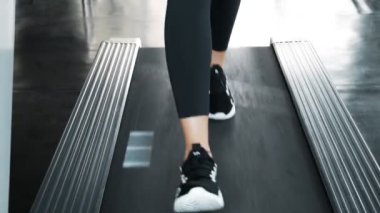 Koşu bandında yürüyen yüksek motivasyonlu beyaz beyaz bir kadın. Sarı saçlı kadın. Otantik fitness yaşam tarzı.