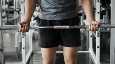 Genç Asyalı adam spor salonunda halter kaldırıyor. Fitness yaşam tarzı.