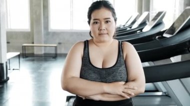 Genç şişman Asyalı kadın portresi. Arka planda jimnastik salonu var. Otantik Fitness yaşam tarzı konsepti.
