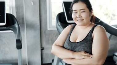 Genç şişman Asyalı kadın portresi. Arka planda jimnastik salonu var. Otantik Fitness yaşam tarzı konsepti.