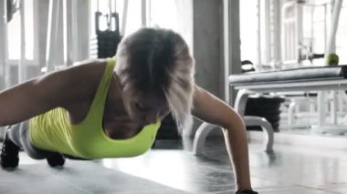 Otantik genç beyaz kadın spor salonunda onu germe excerise başlar. Fitness mobil teknoloji konsepti. 