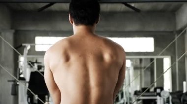 Genç Asyalı adam spor salonunda çapraz kablo eğitim makinesi kullanıyor. Fitness yaşam tarzı.