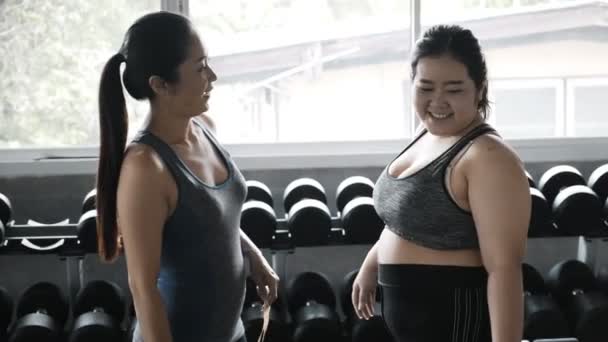 若いプラスサイズの女性は彼女の友人で笑って彼女の腰と腰を測定しようとしています アジアの女性 フィットネスライフスタイル — ストック動画