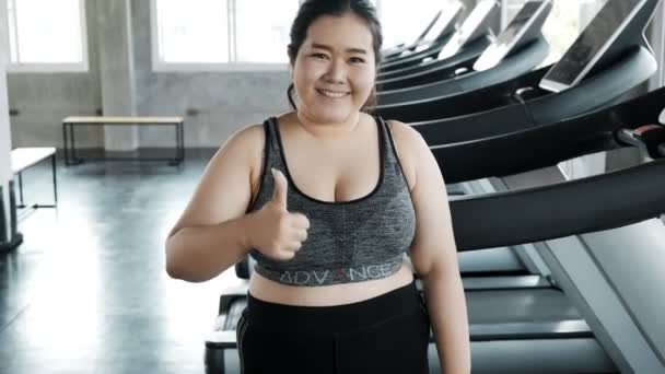 若い脂肪アジアの女性の肖像画 ジムを背景に立ち上がる 本物のフィットネスライフスタイルコンセプト — ストック動画