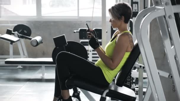 Αθλητική Γυναίκα Χρησιμοποιεί Κινητό Τηλέφωνο Στο Γυμναστήριο — Αρχείο Βίντεο