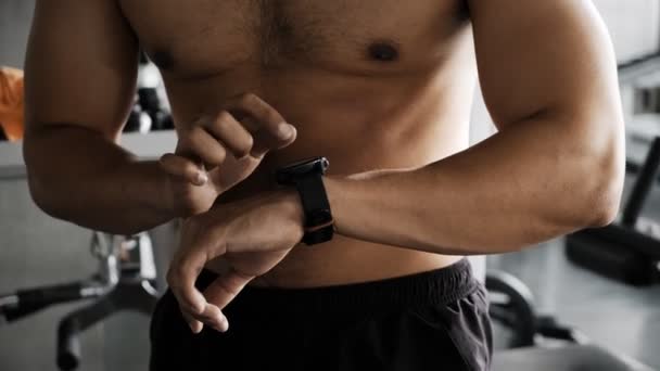 Joven Hombre Asiático Usando Reloj Inteligente Gimnasio Asiático Hombre Pie — Vídeos de Stock