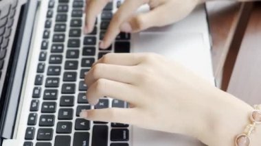 Genç, çekici Asyalı kadın dizüstü bilgisayarda yazı yazıyor, yakın çekim. Milenyum iş kadını yaşam tarzı konsepti.