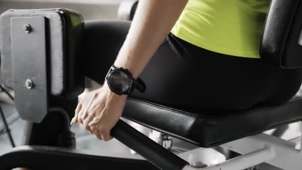 年轻的金发碧眼的高加索女人在健身房用腿引进器用聪明的手表监测她的表现 真正健康的生活方式概念 — 图库视频影像