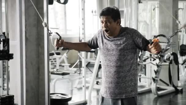 资深的亚洲男子在健身房使用交叉电缆训练机 健身生活方式 — 图库视频影像