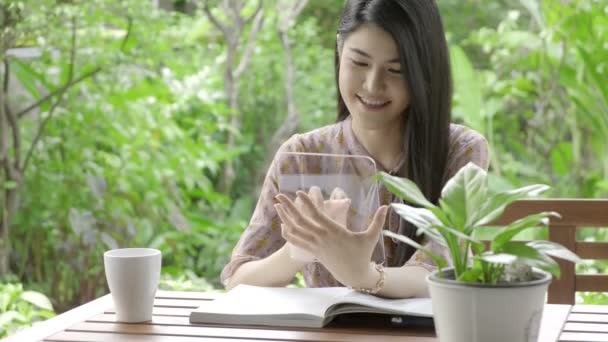 Wanita Asia Yang Cantik Membaca Berita Layar Transparan Kebun Rumahnya — Stok Video