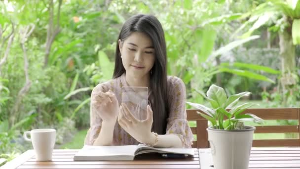 Νεαρή Όμορφη Ασιατική Γυναίκα Περιήγηση Διαφανή Οθόνη Στον Κήπο Του — Αρχείο Βίντεο