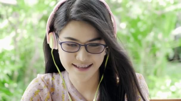 Молодая Привлекательная Азиатская Студентка Слушает Музыку Зеленым Садом Заднем Плане — стоковое видео