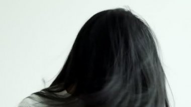 Başını dönen genç güzel Asyalı kadının yavaş hareketi. Güzel saç konsepti.
