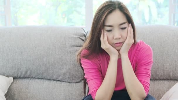 年轻美丽的亚洲女人坐在沙发上看起来很沮丧 孤独和抑郁的概念 — 图库视频影像