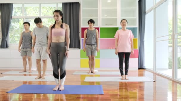 一群年轻的亚洲人和资深的亚洲人参加瑜伽课程 站起来 团体运动生活方式 — 图库视频影像