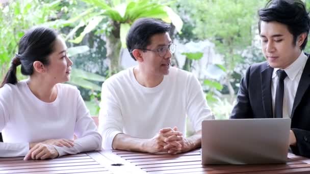 金融アドバイザーと一緒に座っているアジアのシニアカップル 妻は質問を始める 退職準備の概念 — ストック動画