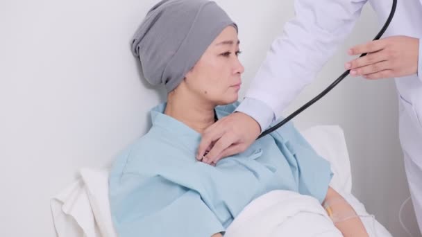 年轻的亚洲医生在床上检查他的老年妇女病人 — 图库视频影像