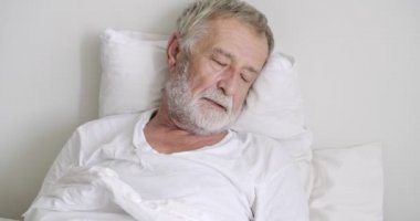 Yaşlı asyalı adam klinikte yatakta uyuyamıyor