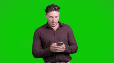 Kafkas adam cep telefonu konuşuyor ve yeşil arka plan üzerinde düşünüyor 
