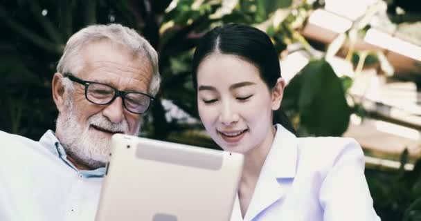 Oude Aziatische Man Jonge Verpleegster Maakt Gebruik Van Tablet Tuin — Stockvideo