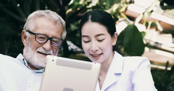 Alte Asiatische Mann Und Junge Krankenschwester Ist Mit Tablet Garten — Stockvideo