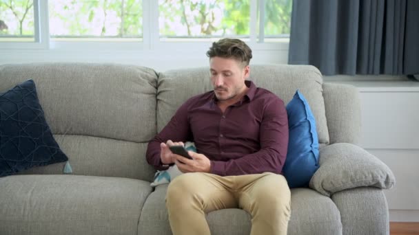 Caucasien Gay Homme Est Assis Sur Canapé Utilisant Téléphone Mobile — Video