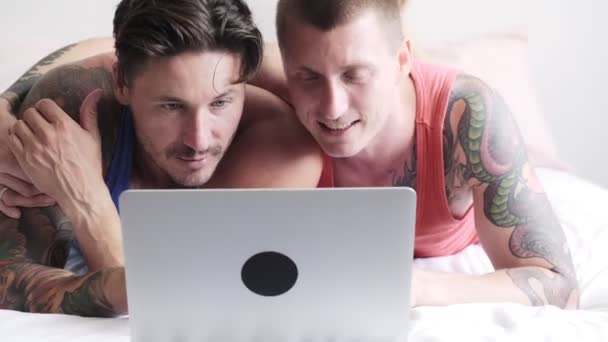 Kaukasiska Homosexuella Par Ligger Sängen Och Titta Något Laptop Hemma — Stockvideo