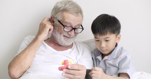 Joven Asiático Chico Utilizando Móvil Teléfono Con Abuelo Clínica — Vídeo de stock