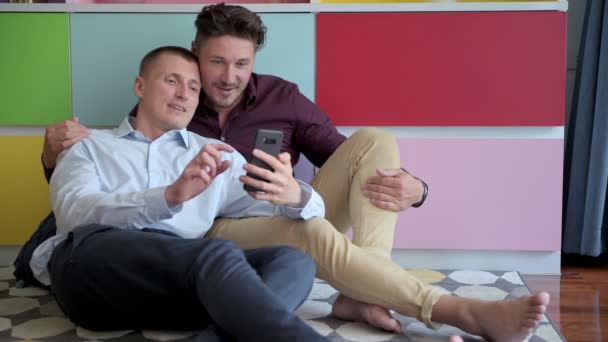 白人のゲイのカップルは 自宅で携帯電話で自分撮りをしています — ストック動画