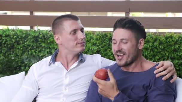 Kaukasische Gay Paar Zit Tuin Het Eten Van Apple — Stockvideo