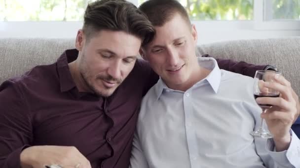 Kaukasische Gay Paar Lezen Boek Drinken Van Wijn Thuis — Stockvideo