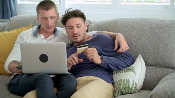 白人同性恋夫妇正在做网上购物笔记本电脑与信用卡电脑在家里 — 图库视频影像