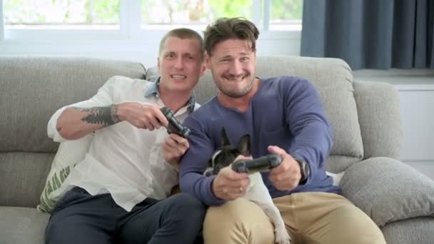 白人のゲイのカップルは 自宅で喜びでビデオゲームをプレイしています — ストック動画