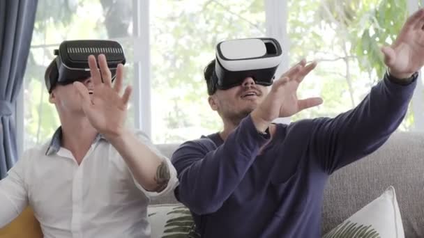 白人同性恋夫妇是使用虚拟现实眼镜在家里 — 图库视频影像
