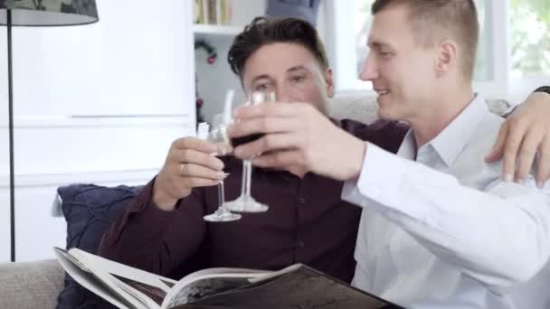 Caucasiano Gay Casal Leitura Livro Beber Vinho Casa — Vídeo de Stock