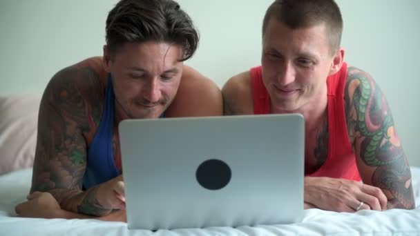 Kavkazský Gay Pár Leží Posteli Sleduje Něco Přenosném Počítači Doma — Stock video