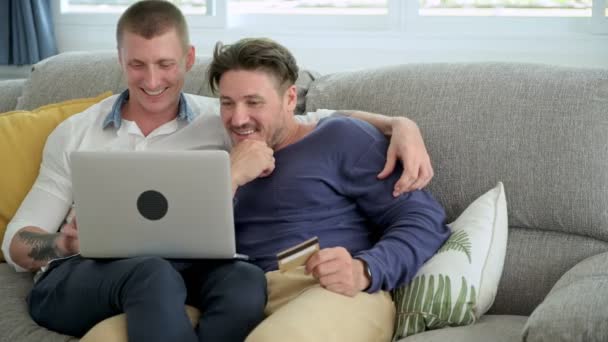 白人同性恋夫妇正在做网上购物笔记本电脑与信用卡电脑在家里 — 图库视频影像
