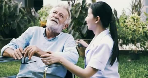 Young Nurse Talking Mature Disabled Man Wheelchair Garden — Stock Video